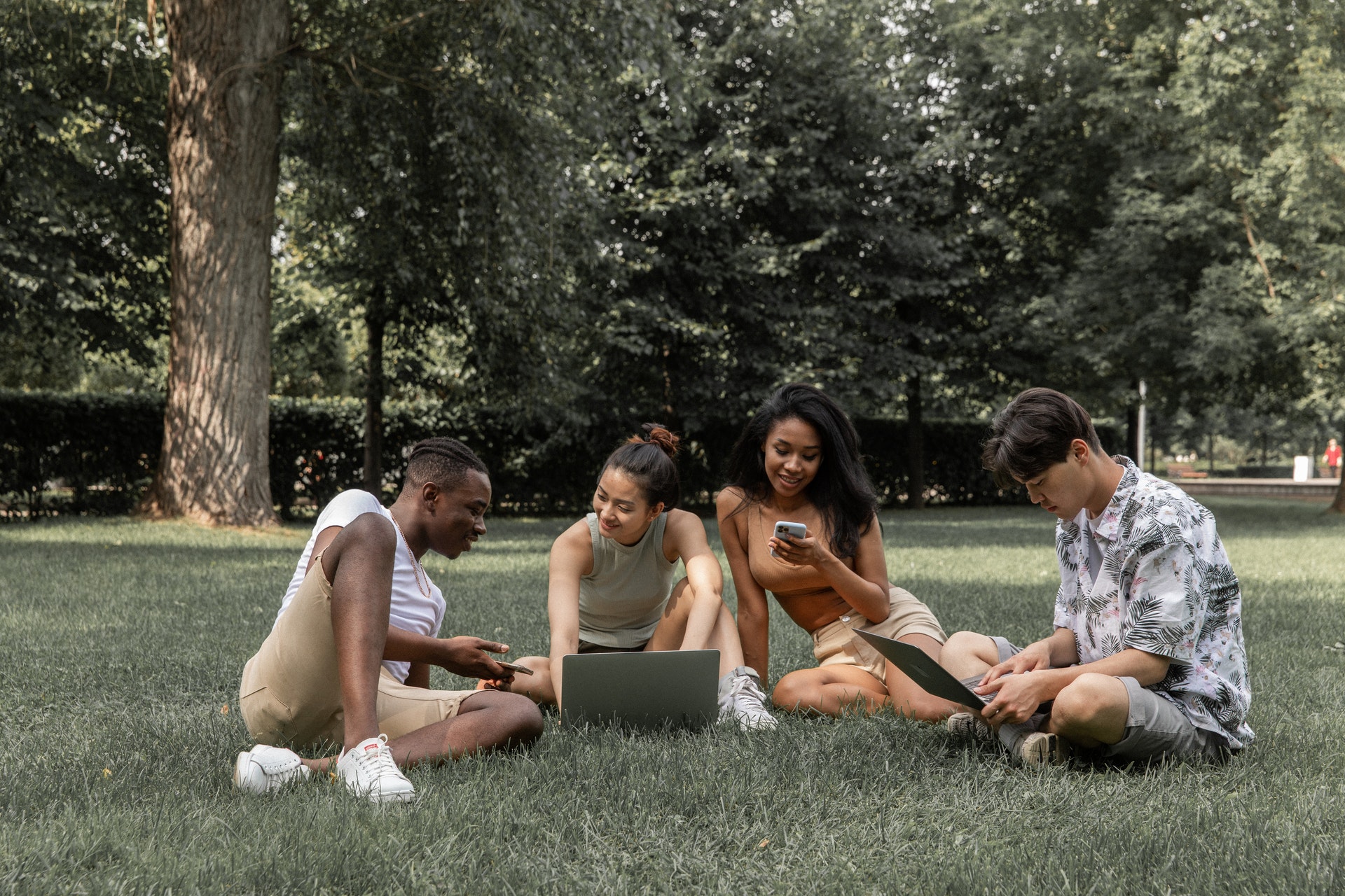 Four multiethnic people using their devices