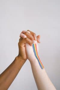 Rainbow flag hands clasped in collaboration