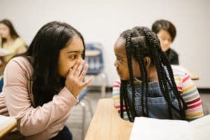 Young kids whispering in an early stage of identity development