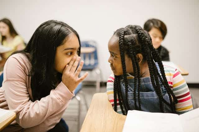 Young kids whispering in an early stage of identity development