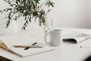 Calm office scene with a coffee mug, notepad, and newspaper