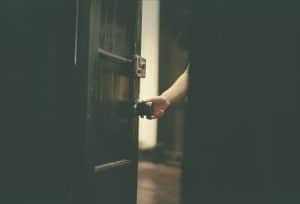 Someone's hand opening a door by the knob