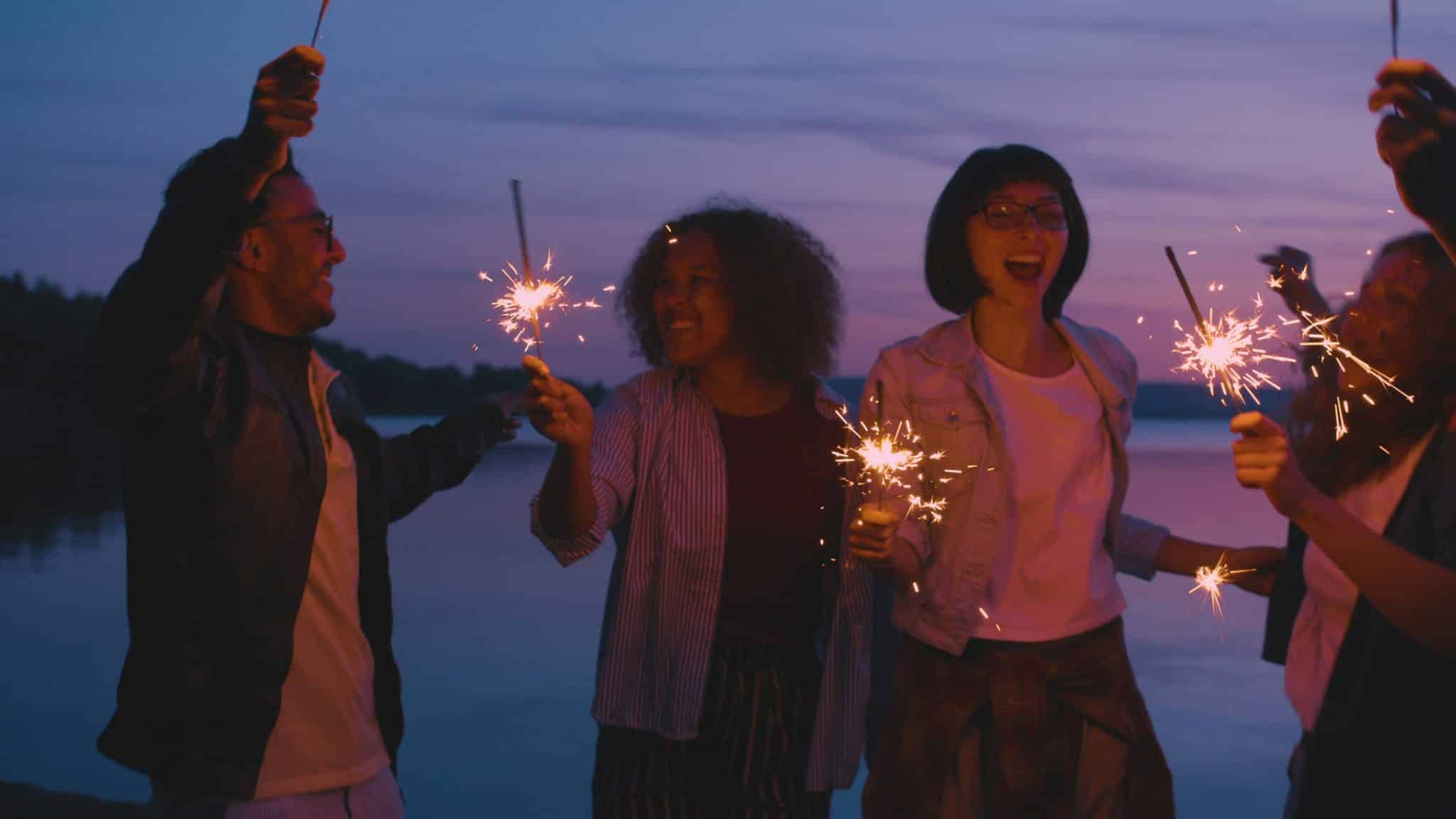 Four people after dusk with sparklers